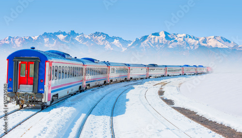 Red diesel train (East express) in motion at the snow covered railway platform - The train connecting Ankara to Kars - Turkey 