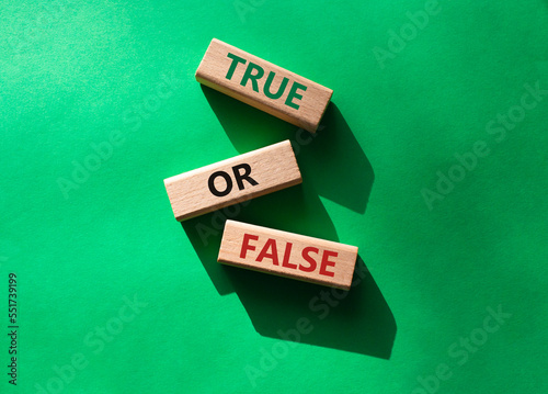 True or false symbol. Wooden blocks with words True or false. Beautiful green background. Businessman hand. Business concept and True or false. Copy space.