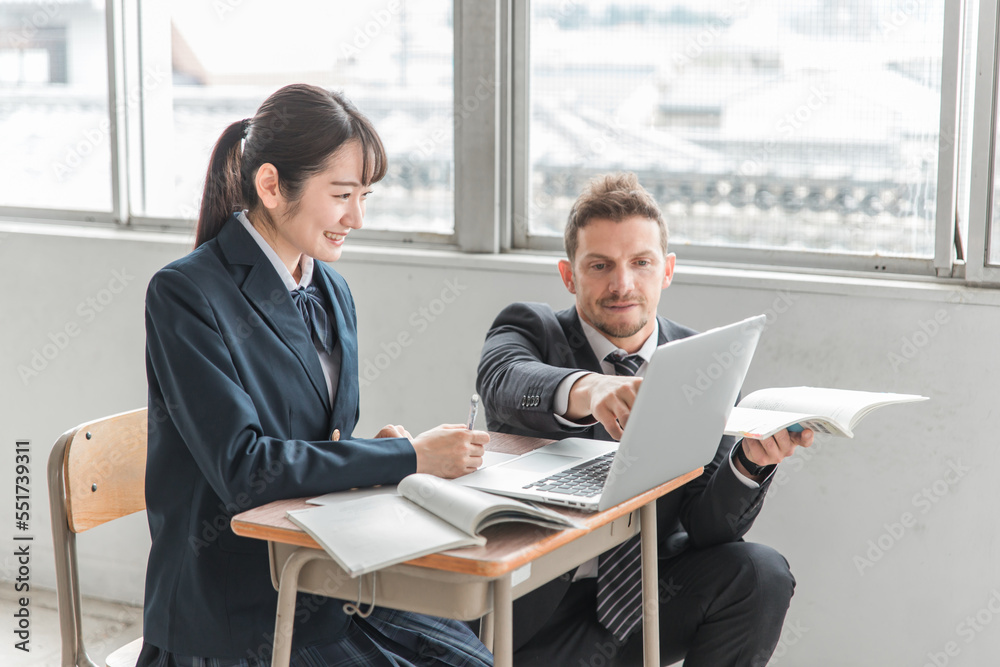 学校・塾でノートパソコンを使って勉強する高校生・中学生と外国人講師（ICT教育）
