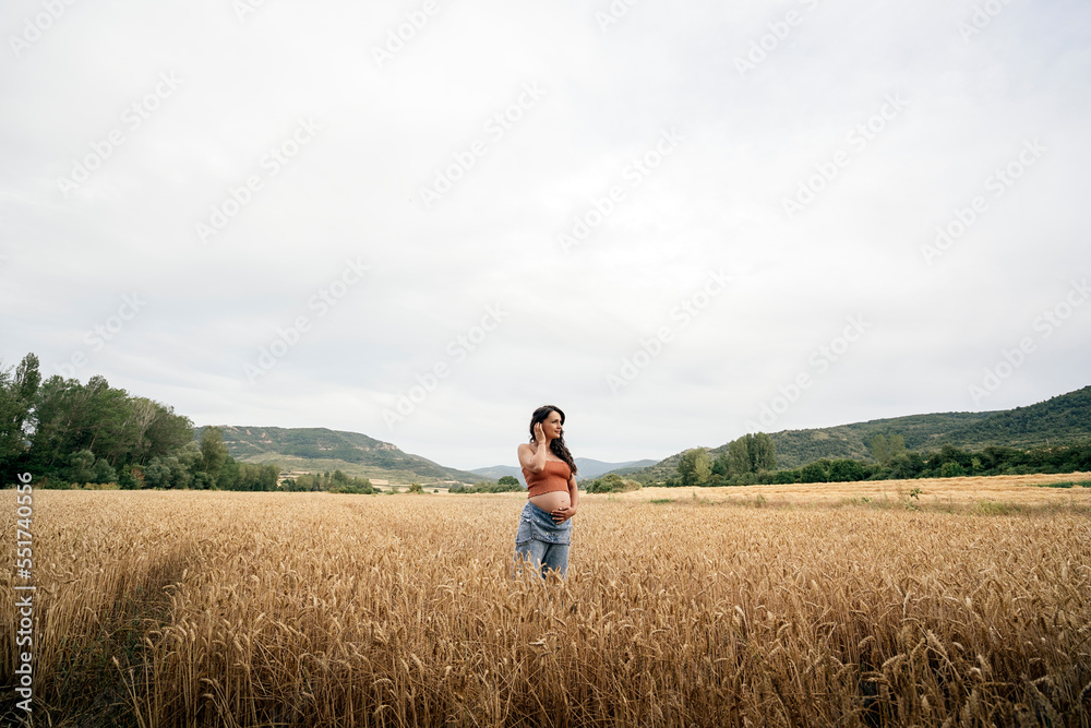 Pregnant young woman in wheat field