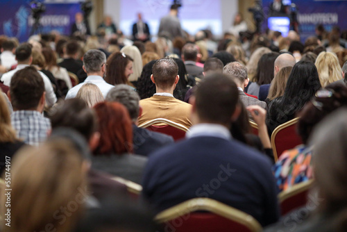 Shallow depth of field (selective focus) details with a crowd of people attending a conference indoors. © MoiraM