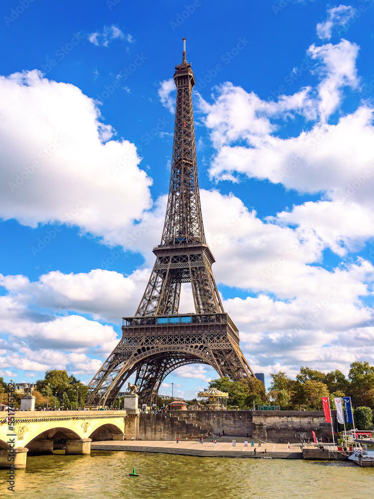 Eiffel Tower in Paris with blue sky and white clouds and Seine River