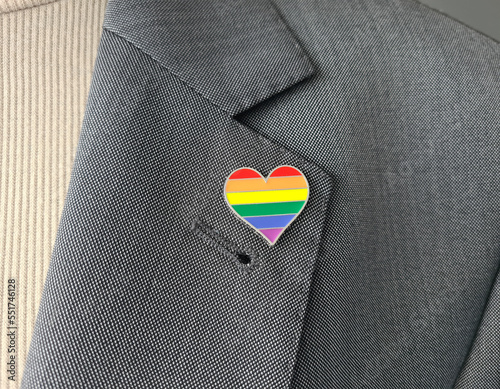 Metal badge with lgbt flag on lapel of man or woman suit photo