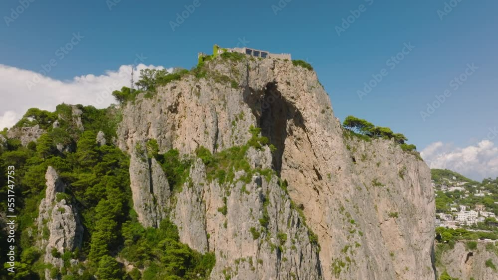Aerial ascending footage of modern design residence on top of high cliff on sunny day. Capri, Campania, Italy