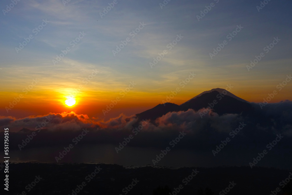 Sunrise in the cloudy mountain top with hues of orange and purple. 