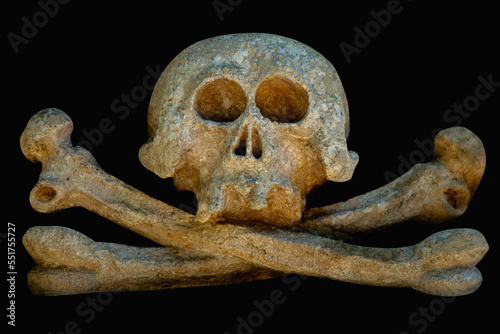 Close up an ancient statue of human skull head against black background.