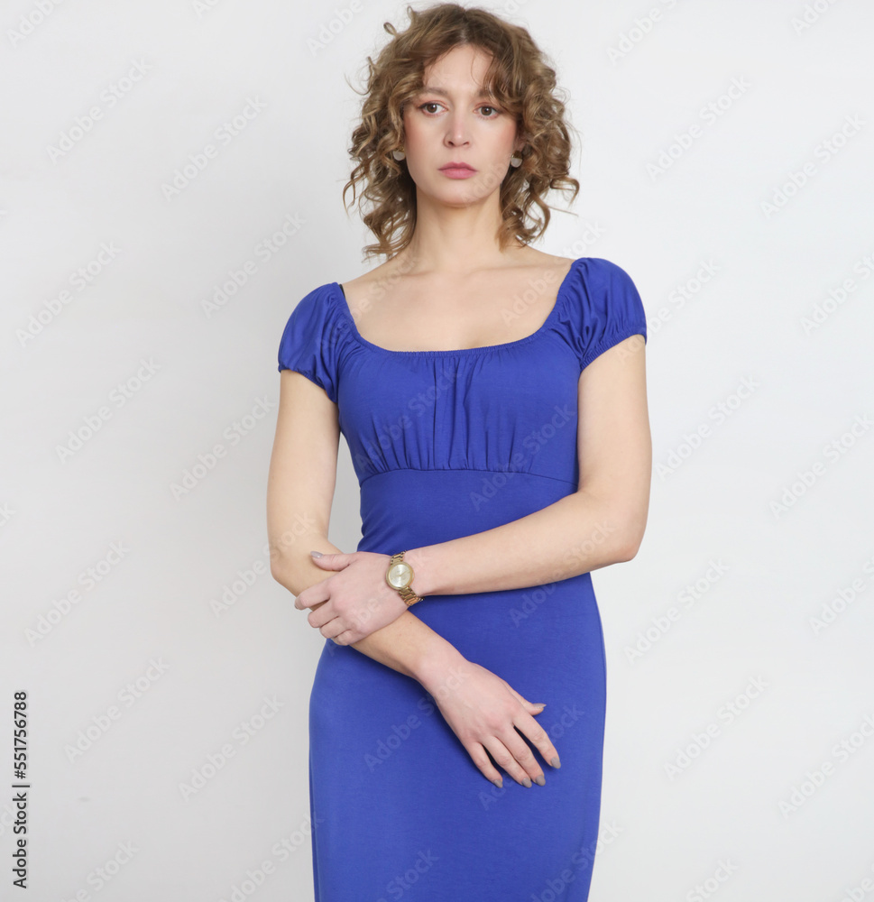 Studio photo of young female model in long elastic royal blue classic and versatile off the shoulder dress. Studio photo of young female model in long elastic royal blue classic and versatile off the shoulder dress.