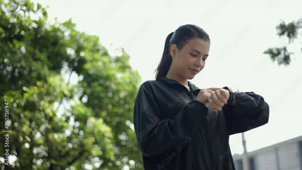 Portrait young beautiful woman checking sportswear adjusting smart watch before workout in park. Cheerfully sporty female workout and exercise in the morning. Healthy and active lifestyle concept. Portrait young beautiful woman checking sportswear adjusting smart watch before workout in park. Cheerfully sporty female workout and exercise in the morning. Healthy and active lifestyle concept.