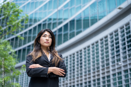 Confident Asian business woman with crossed arms for her achievements, modern skyscrapers background, female businesswoman of Japanese origins, copy space Free Download Confident Asian business woman with crossed arms for her achievements, modern skyscrapers background, female businesswoman of Japanese origins, copy space - GFXLoad