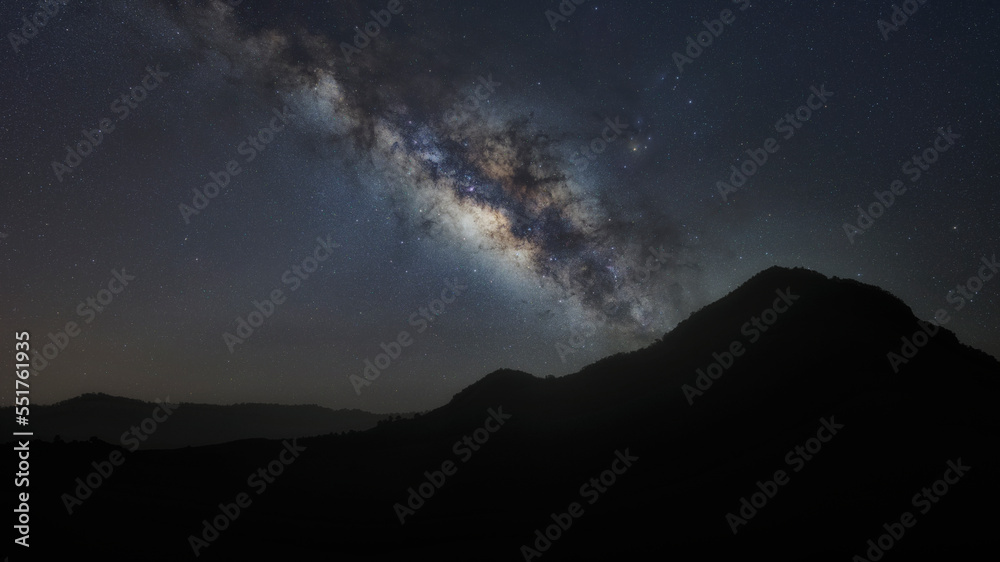 panorama mountain silhouette and blue night sky milky way and star on dark background. universe called,nebula and galaxy with noise and grain. Cassiopeia is a constellation in the northern sky. 