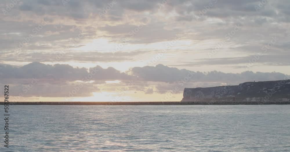 4K Timelapse of sun rising behind the clouds at the Mediterranean sea with mountain in the background 4K Timelapse of sun rising behind the clouds at the Mediterranean sea with mountain in the background