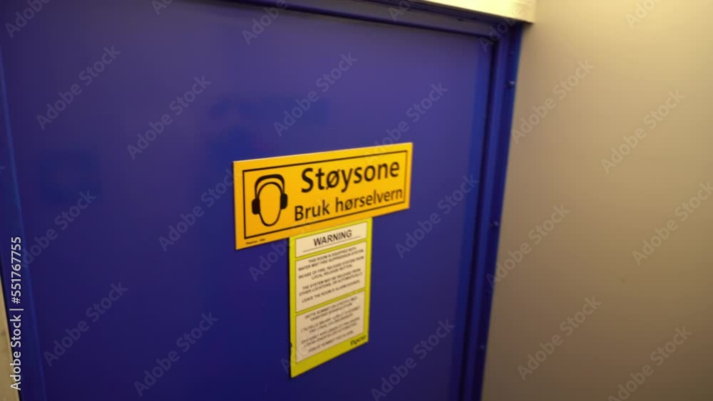 Sign warning about noise zone on door to ships engine room - Norwegian language on sign