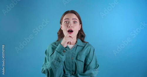 Puzzled young woman thinking about something and came up with solution. Got idea. Light blue background