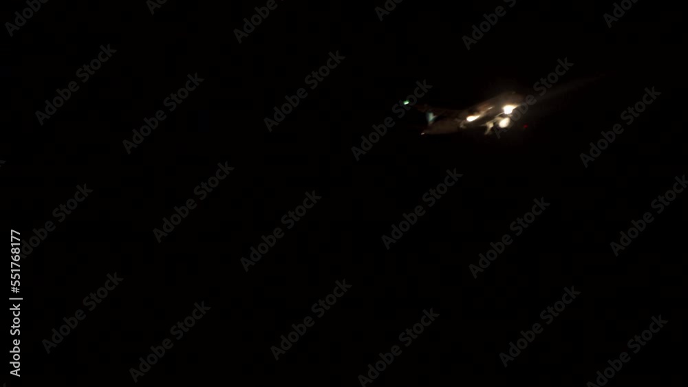 Airplane flying in dark night sky - The plane is landing
