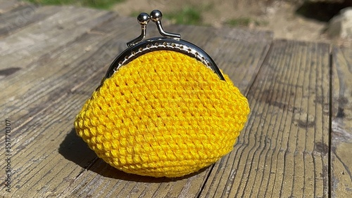 Soft focusing yellow purse bag crochet on the wooden table