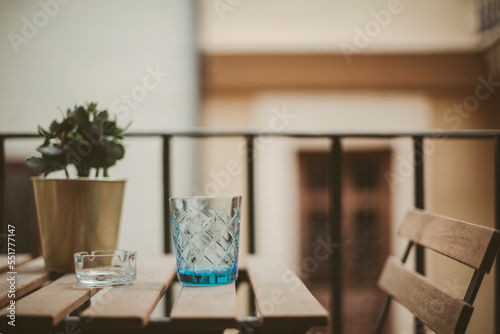 Close-up of a glass, an ashtray and a houseplant on a wooden table photo