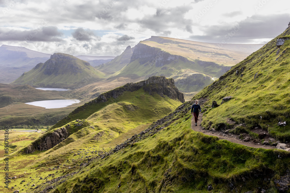 Woman hiking on Quiraing.It is a geological formation on the Scottish Isle of Skye and a hiker's paradise