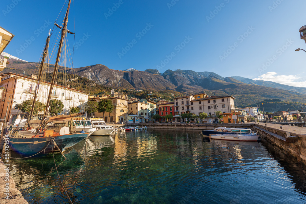 Malcesine village. Port with small boats and ferries moored and colorful houses. Famous tourist resort on the coast of Lake Garda (Lago di Garda). Verona province, Veneto, Italy, southern Europe.