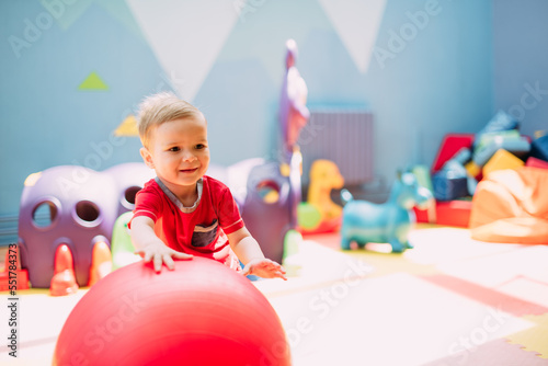 фотографія Happy laughing boy 1-2 years old having fun in ball pit  in kids amusement park and indoor play center