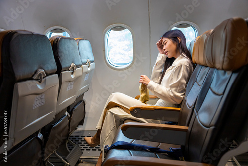 Εκτύπωση καμβά Asian woman is feeling dizzy and holding to vomit bag during the flight in the a