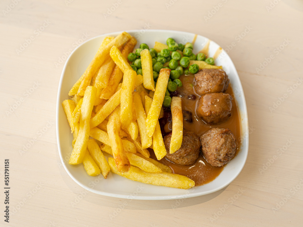 Meatballs with French Fries, Green Peas, Bechamel Sauce on White Plate Meatballs with French Fries, Green Peas, Bechamel Sauce on White Plate