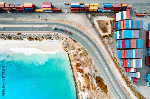 Shipping containers at Fremantle Port with white sandy beach and crystal clear blue sea photo