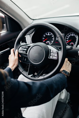 Close up of steering wheel in male driver hand, copy space. Man's hand holding steering wheel inside car