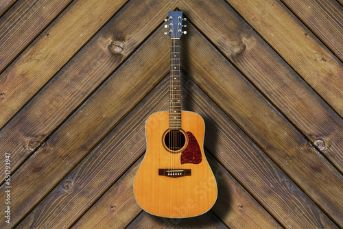 acoustic guitar on wooden surface in background 