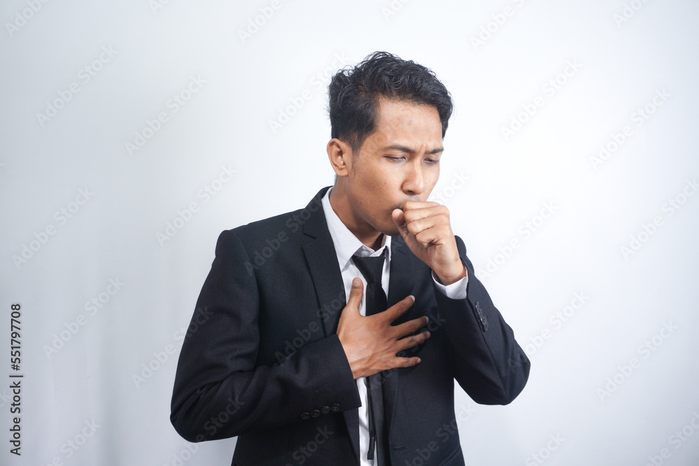 Man in suit coughing into his fist, isolated on a gray background. Man in suit coughing into his fist, isolated on a gray background.