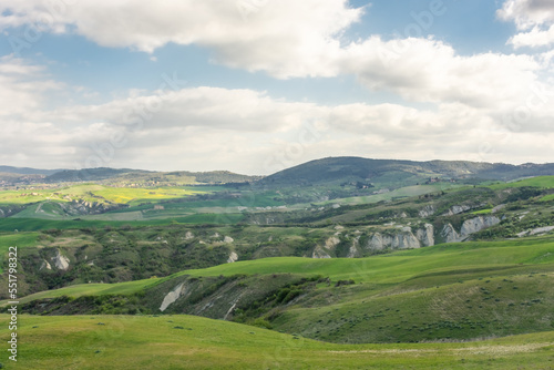 The landscape of the Crete Senesi, with green hills and rocks, Tuscany