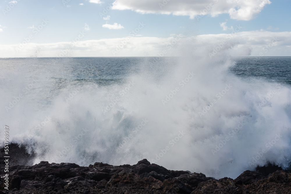 Powerful waves of the Atlantic Ocean crashing on the volcanic cliffs of Los Hervideros in Lanzarote,  Canary Islands, Spain