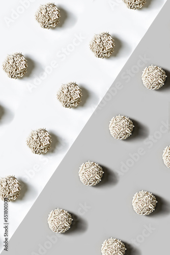 Flat lay photo of the cat litter put in the geometric pattern on the white-gray background.