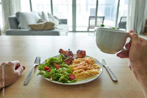 Lunch of pasta and fresh salad in an apartment with a panoramic view of downtown