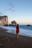 Woman standing back and looking at Aphrodite's Rocks, Cyprus
