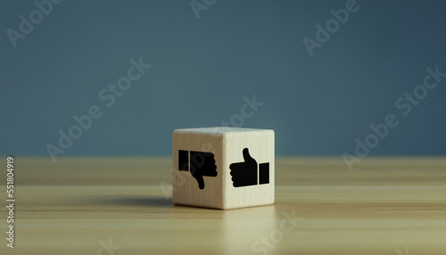 Wooden cube with Thumbs up down hands agree and disagree gesture, Like and dislike symbol, positive vs negative gesture photo