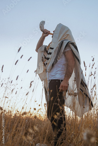 Canvas Print Jewish man in a traditional tallit prayer shawl blowing the ram's horn shofar, i