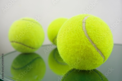 Three tennis balls reflected in green tones