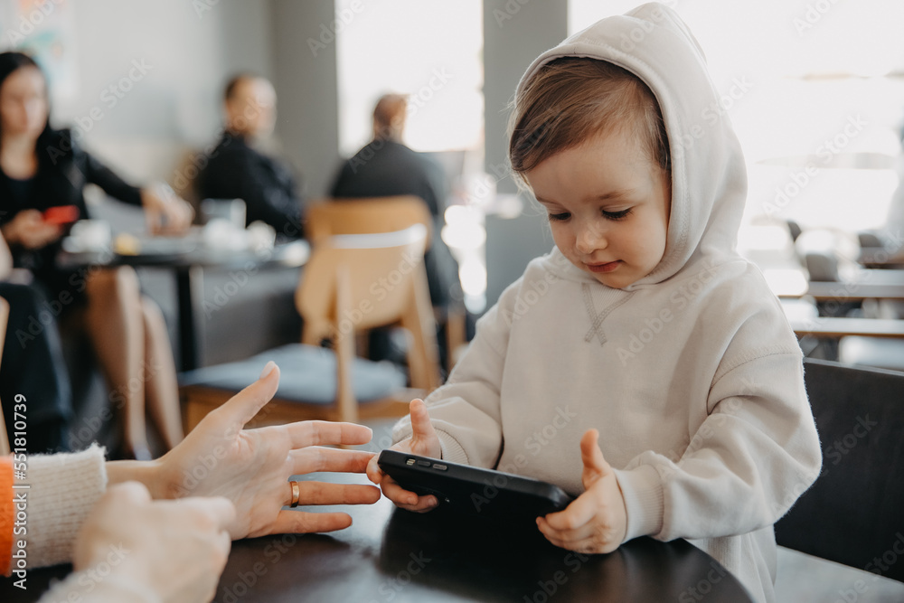 A little kid has a gadget addiction, plays gadgets all the time, watches videos on a smartphone A little kid has a gadget addiction, plays gadgets all the time, watches videos on a smartphone