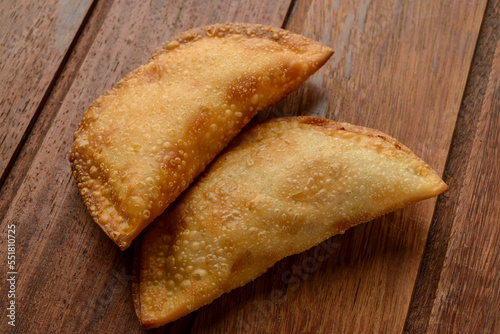 Pastries on wooden background. Traditional Brazilian snack known as "pastel".
