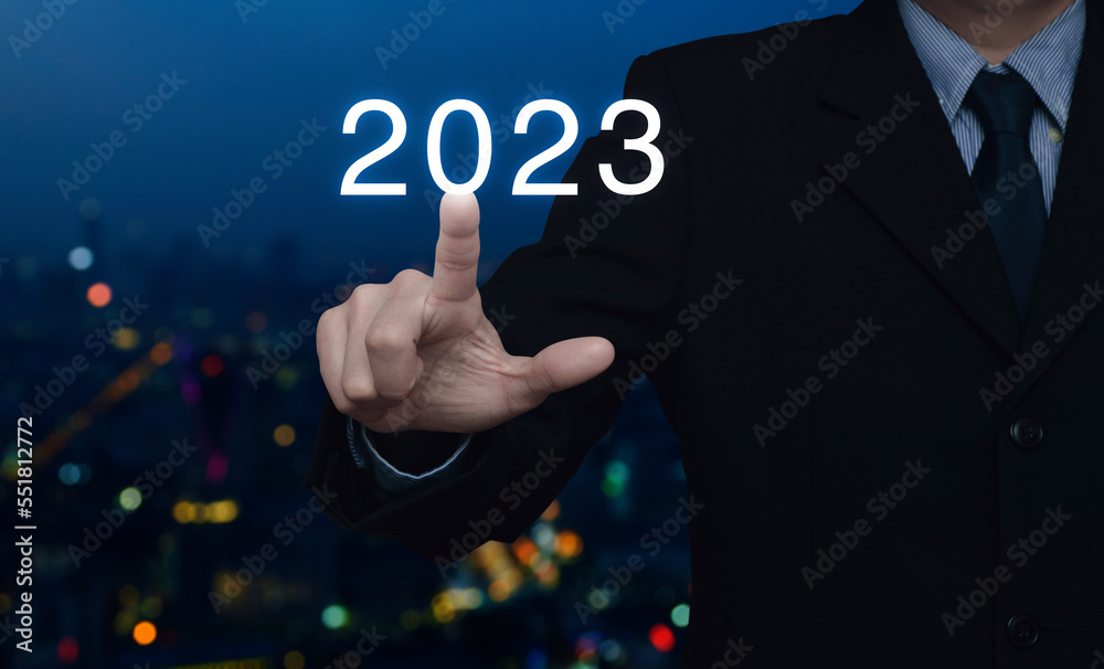 Businessman pressing 2023 letter over blur colorful night light modern city tower and skyscraper, Business happy new year 2023 cover concept Businessman pressing 2023 letter over blur colorful night light modern city tower and skyscraper, Business happy new year 2023 cover concept