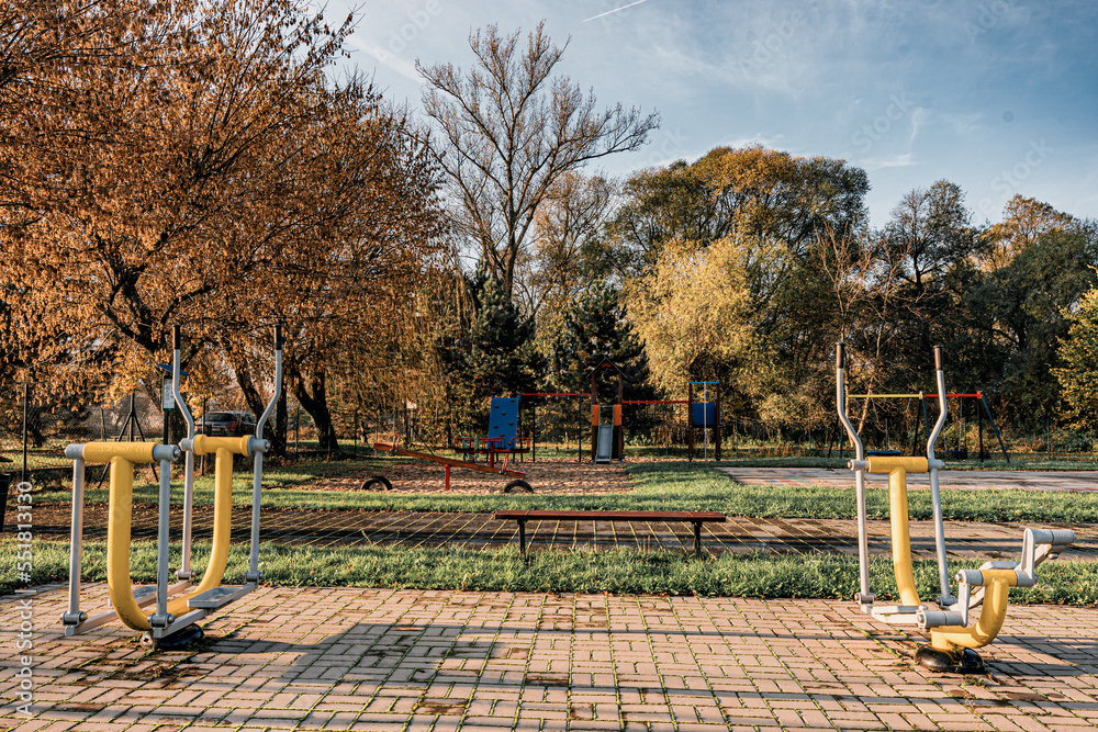 wiejski plac zabaw jesienią z huśtawkami, zjeżdżalniami, i ściankami do wspinaczki dla dzieci