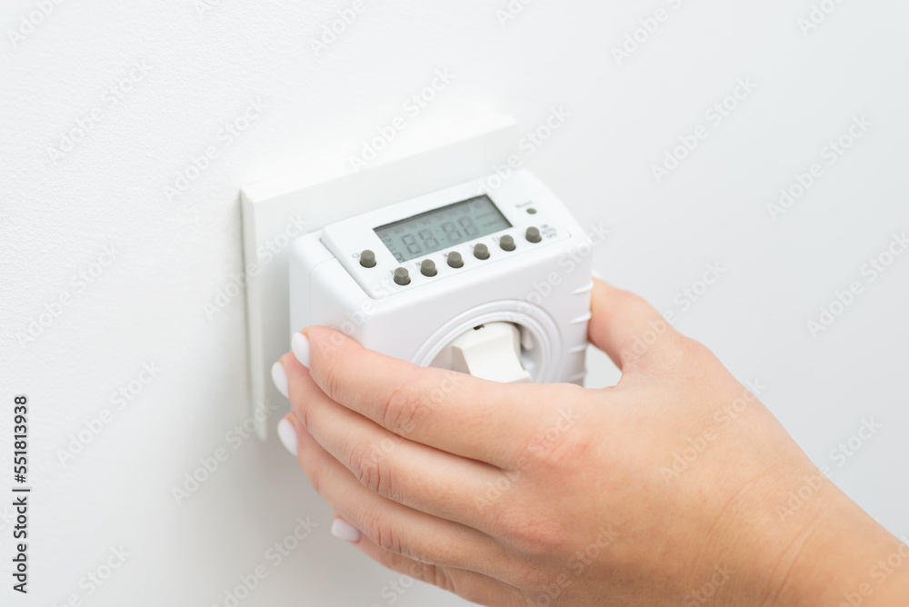 Turning on outlet computer that counts and saves energy, turns on and off socket. Plug in the controller of electricity into European socket Turning on outlet computer that counts and saves energy, turns on and off socket. Plug in the controller of electricity into European socket
