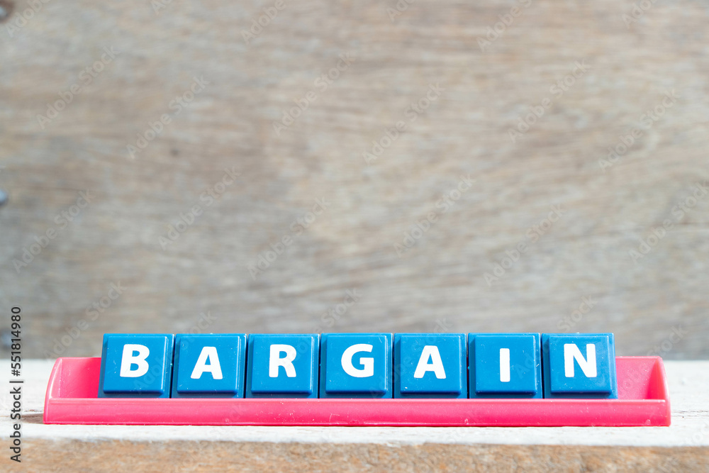 Tile alphabet letter with word bargain in red color rack on wood