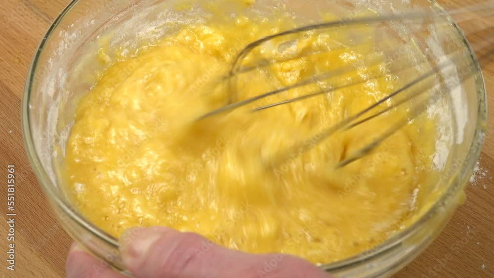 Liquid dough are whisking with wire wisk in a glass bowl in a glass bowl, making of the dough for baking Liquid dough are whisking with wire wisk in a glass bowl in a glass bowl, making of the dough for baking
