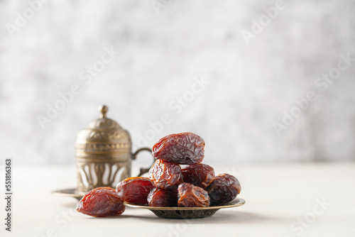 Cup of coffee and dry dates on saucer ready to eat for iftar time. Islamic religion and ramadan concept. photo