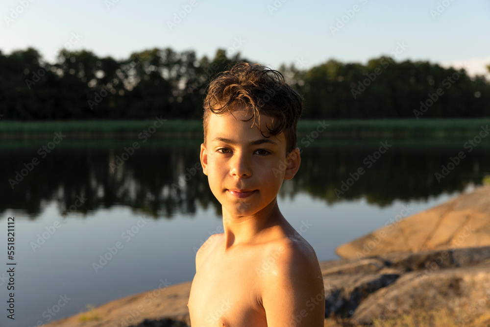 Side view portrait of shirtless boy against lake during sunset Side view portrait of shirtless boy against lake during sunset