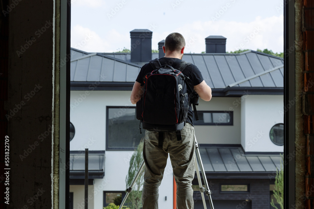 An interior photographer on a construction site takes a photo from a tripod for the website.