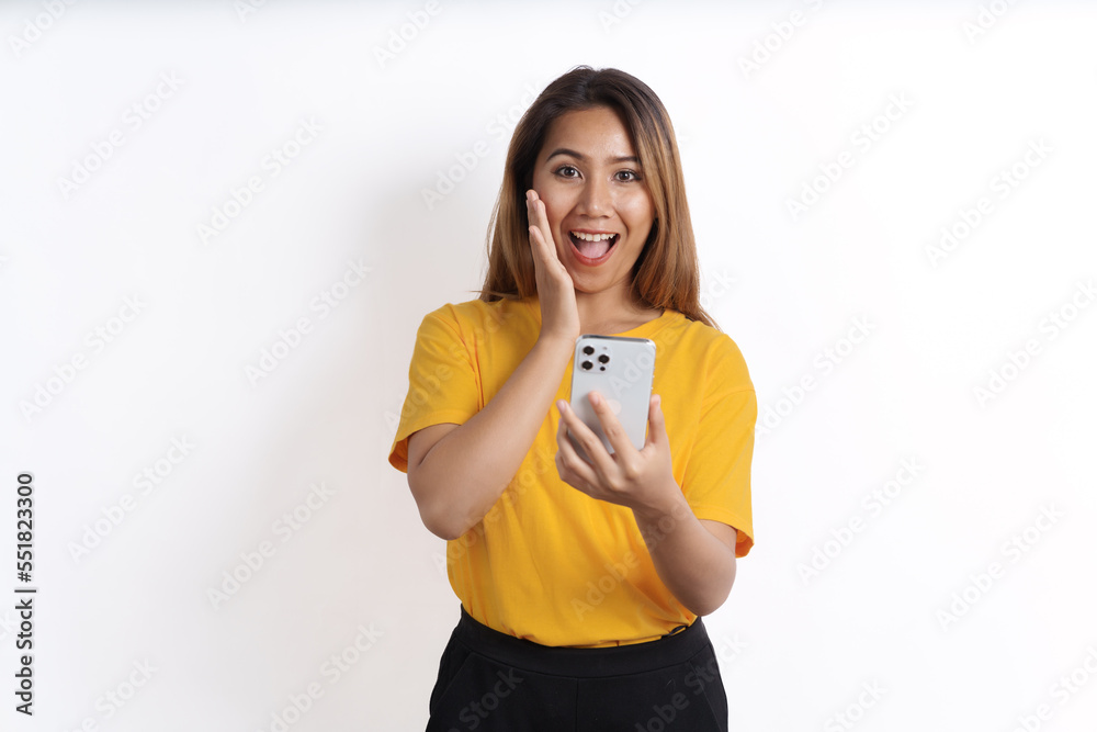 Hot asian pretty young woman smiling isolated on white, yellow t-shirt, using cellphone Hot asian pretty young woman smiling isolated on white, yellow t-shirt, using cellphone