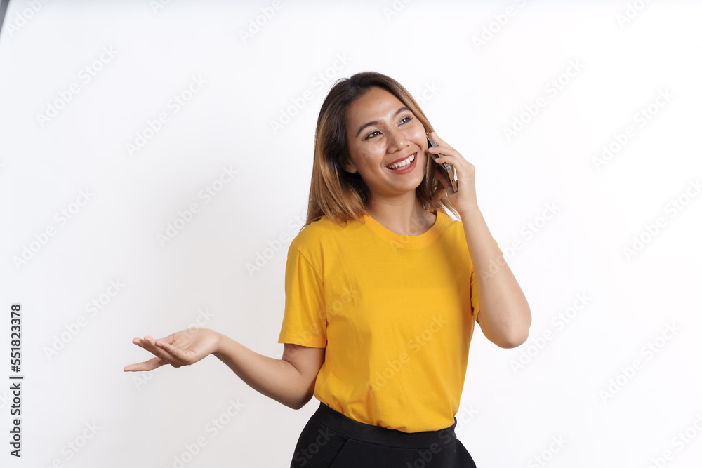 Hot asian pretty young woman smiling isolated on white, yellow t-shirt, make a mobile call Hot asian pretty young woman smiling isolated on white, yellow t-shirt, make a mobile call