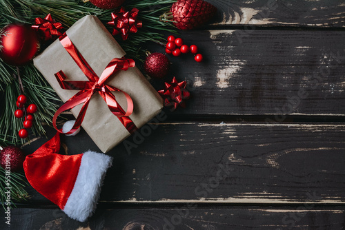 Christmass background gift boxe,red christmas tree toys,Santa hatn and spruce brance on wooden background. photo